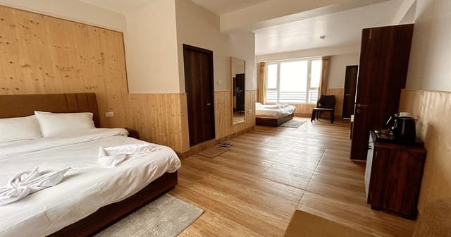 Family room at Floret Resort Lachung with two double beds and pine-panelled walls