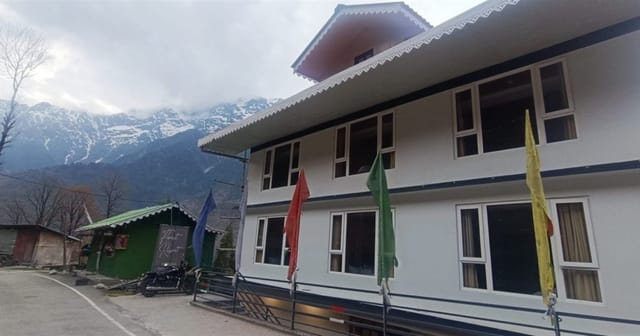 Floret Resort beside the mountain road in Lachung, with snowy Himalayan peaks behind it